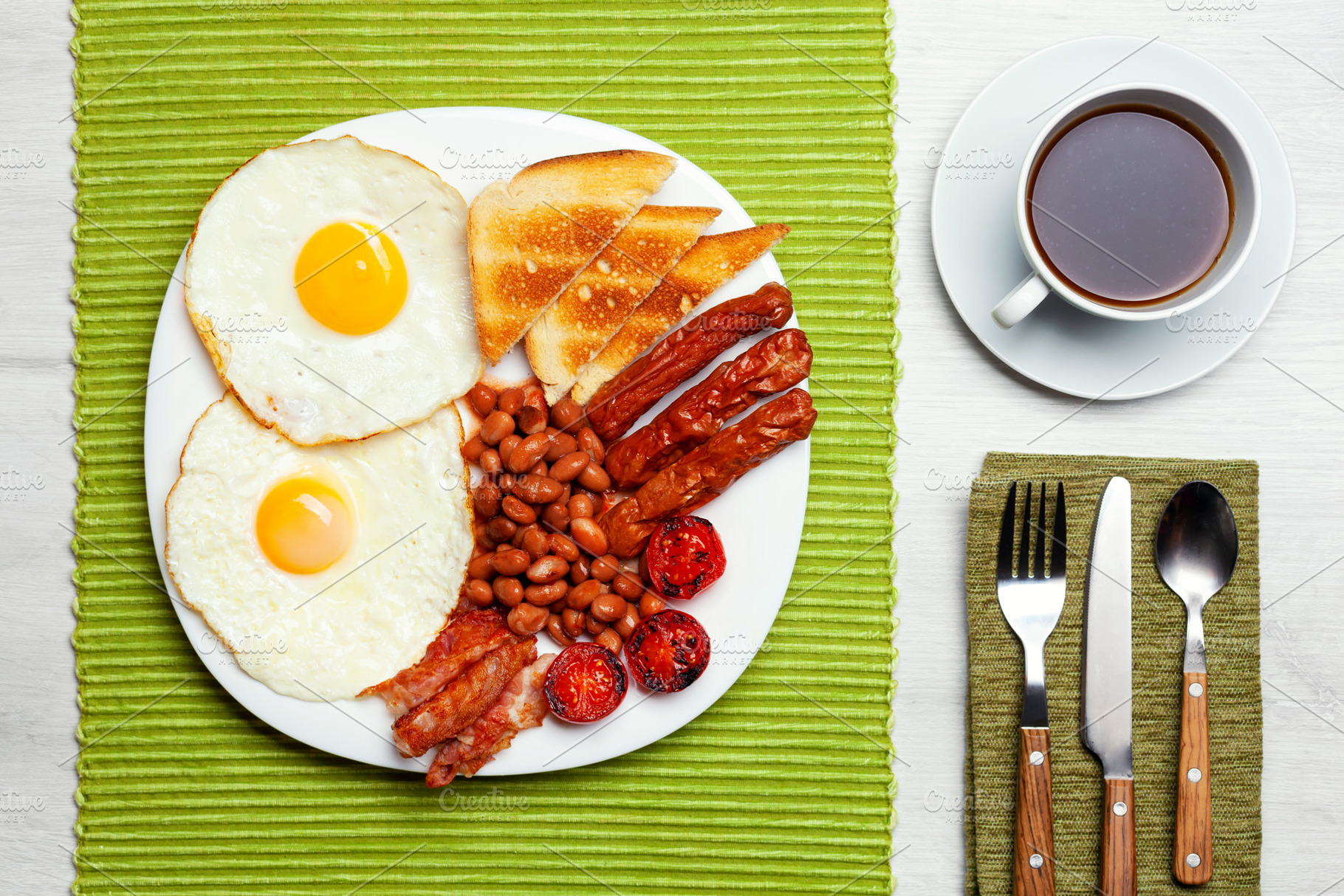 Full English breakfast with fried eggs, sausages, bacon, beans, toast and a cup, a Food & Drink Photo by Antonio Gravante Market