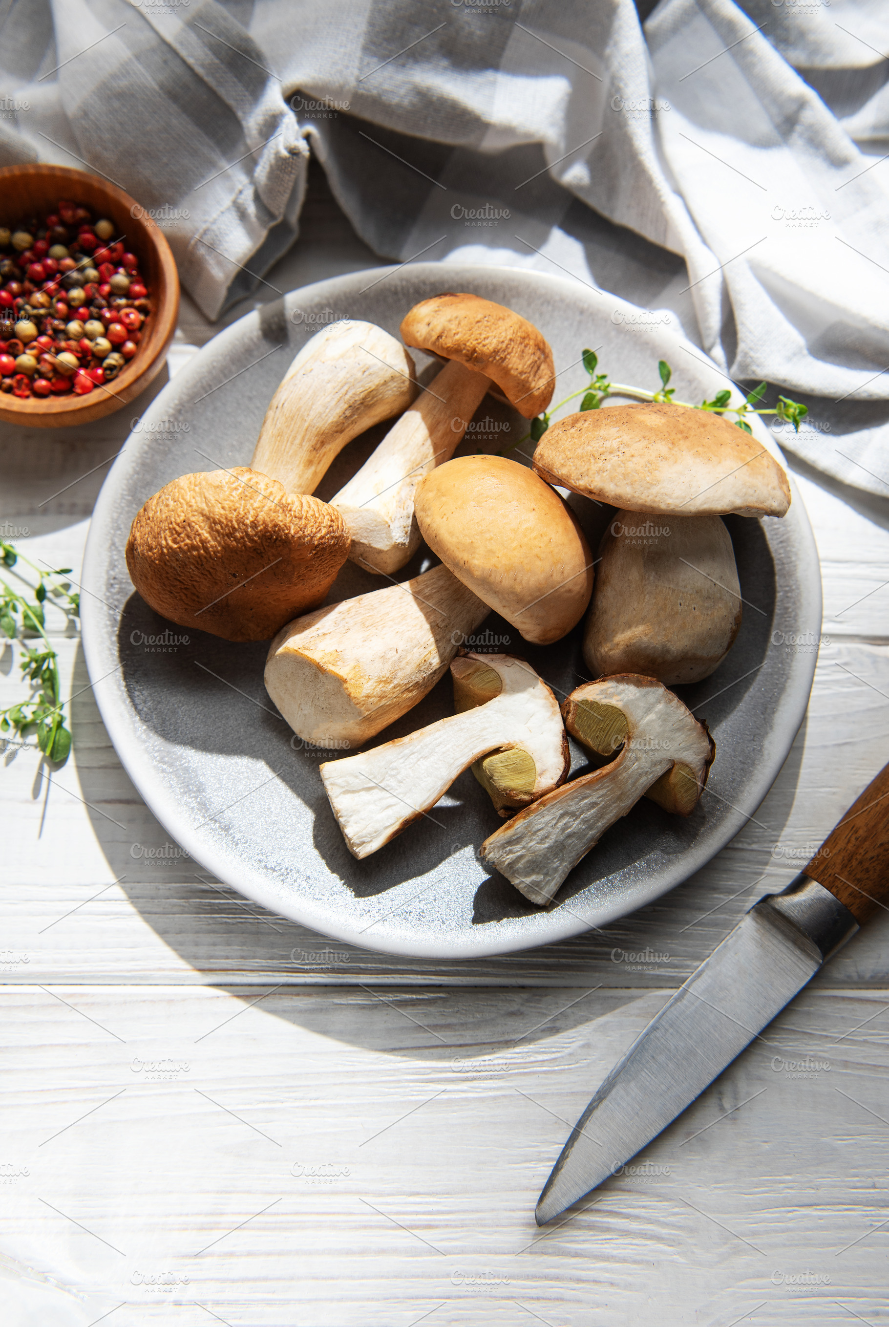 Fresh porcini mushrooms preparing for cooking with herbs, a Food & Drink Photo by Olena Rudo