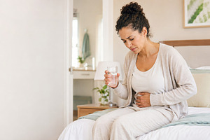 Woman experiencing abdominal pain at, a Photo by Dvoevnore photos
