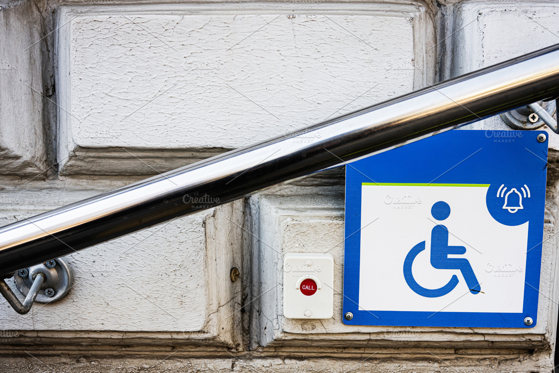 Accessible entrance sign with call button and rail for wheelchair users, a Photo by AS photostudio