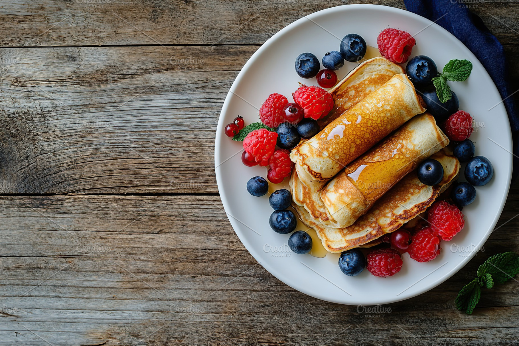 Rolled pancakes served with fresh berries and syrup on a rustic wooden table, a Food & Drink Photo by AlyaAnd