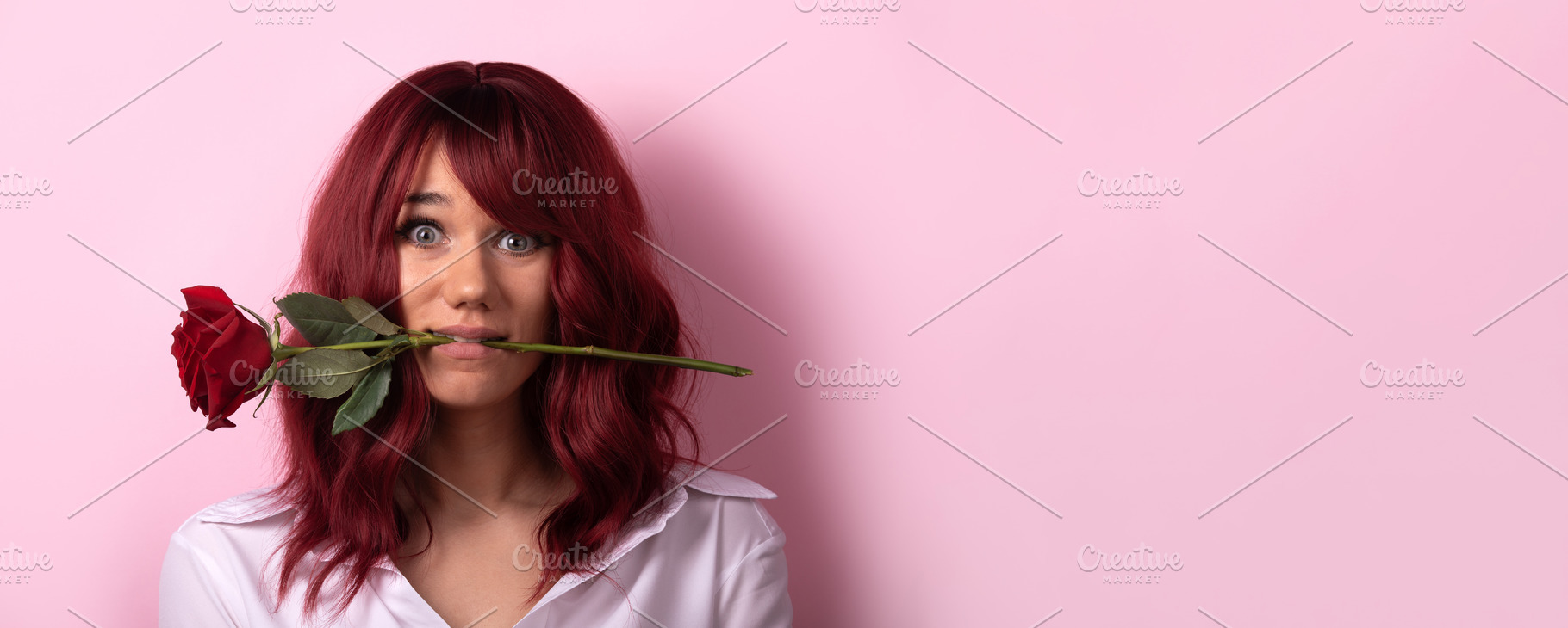 Young woman with red hair holding a red rose in her mouth, smili, a Person Photo by Ales Munt