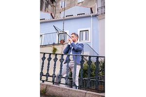 Man plays harmonica outdoors in city