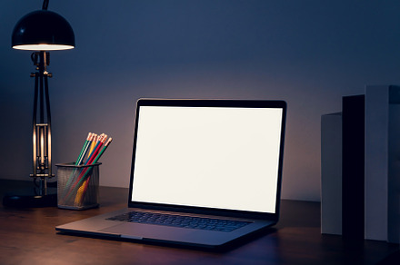 Laptop a blank screen on the table at night for putting on a computer advertise