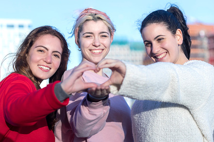 Three friends forming a heart with hands, a Person Photo by RF Images