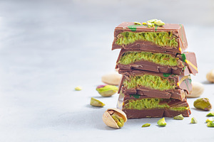 Stack of chocolate bars with pistachio and kadaifi filing, horizontal copy spac, a Food & Drink Photo by iuliia_n