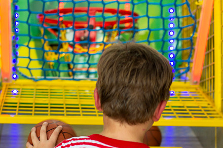 boy throws basketball in basket
