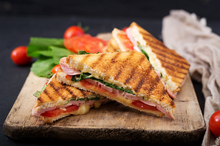 Club sandwich panini with ham containing appetizer, basil, and bbq