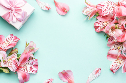 Beautiful Alstroemeria flowers and gift boxes on light green bac, a Holiday Photo by Olena Rudo