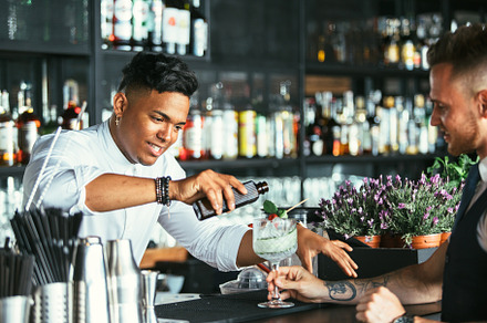 Bartender prepares a cocktail containing cocktail, bartender, and barman
