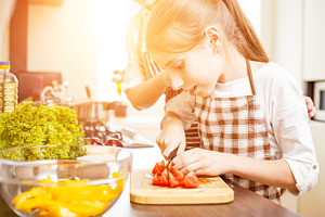Young teenage girl cook together with her family containing family cooking