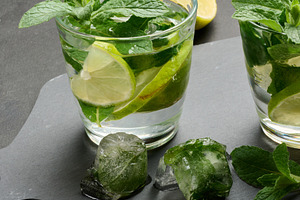 Refreshing mojito cocktail with lime, mint, and ice on dark back, a Nature Photo by ndanko
