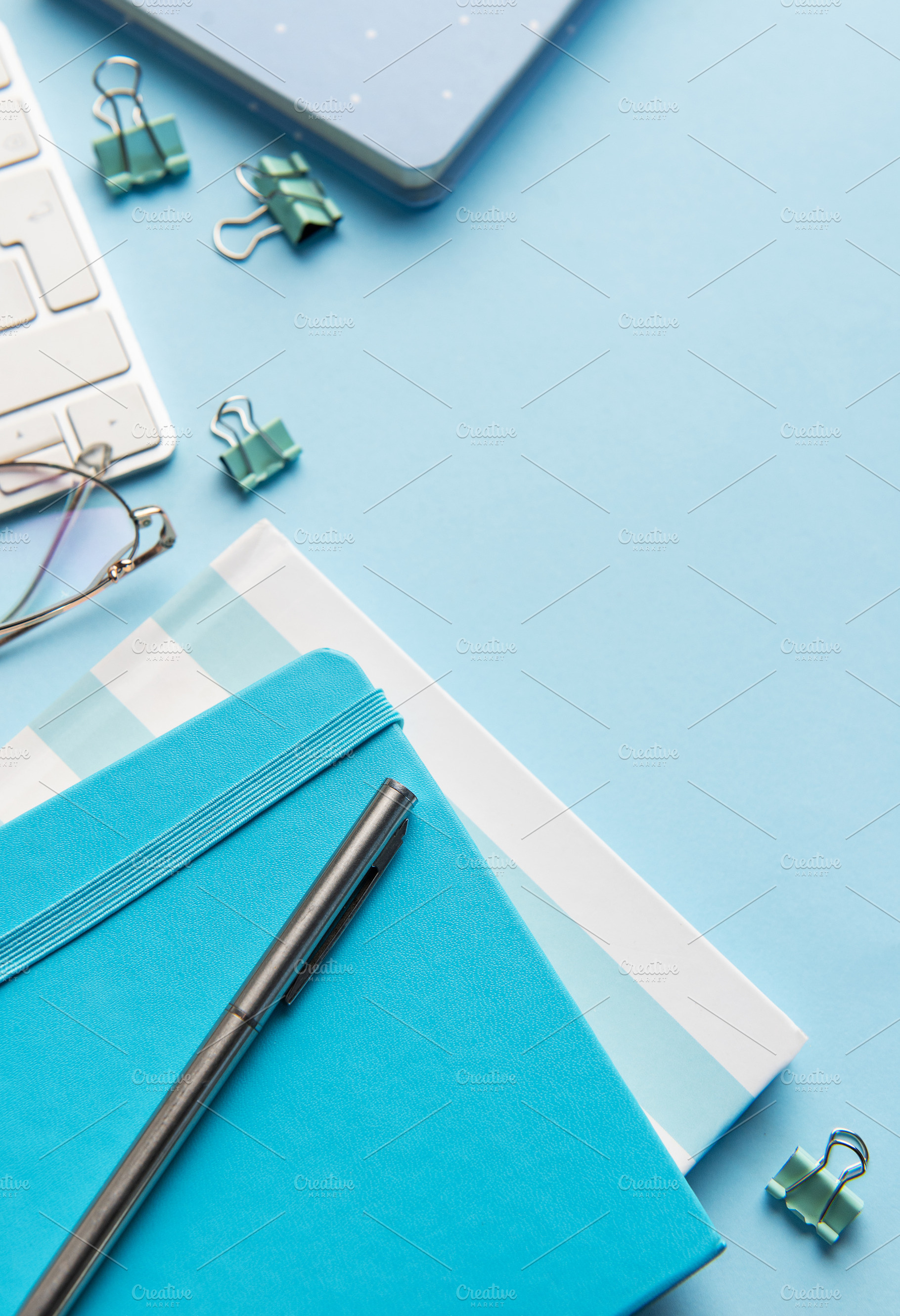 Office workspace with keyboard, notebooks, and blue supplies, a School & Education Photo by Olena Rudo