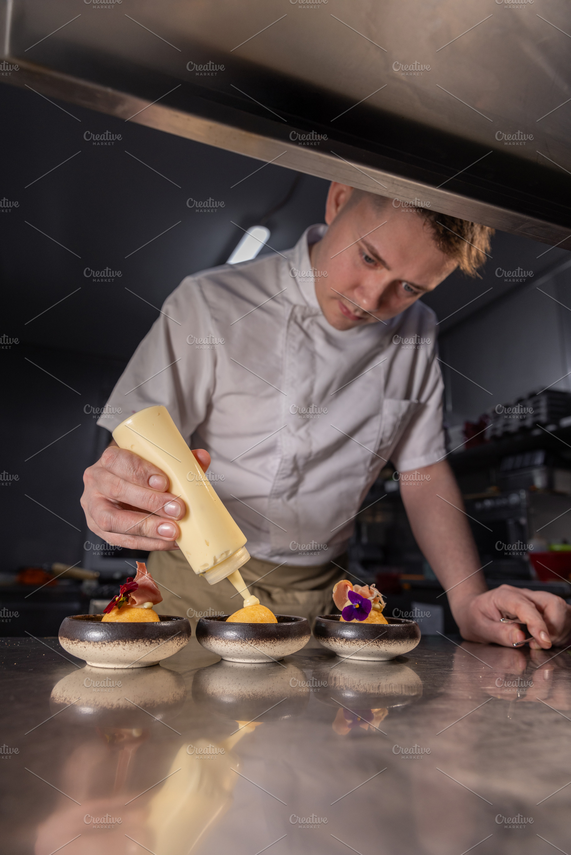 Chef garnishing small dishes, a Photo by Grafvision photography