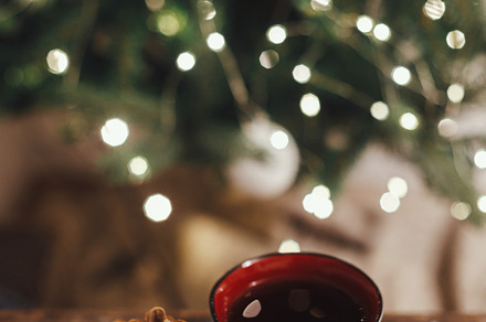 Stylish cup and pine cone on rustic wood at christmas tree in li, a Holiday Photo by Sonjachni