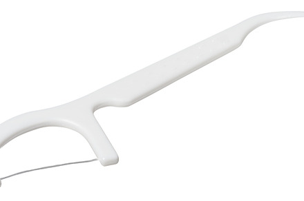 White plastic dental flosser on isolated background. Oral hygien