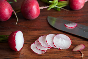 Fresh radishes on wooden board containing cutting board, food, and fresh