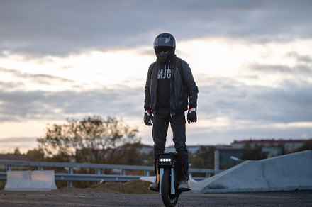 A man rides on an electric unicycle. Mono Wheel riding (EUC) , protective gear