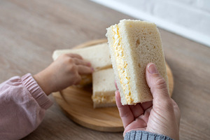 Woman taking a tamago Sando sandwich wth her daughter, a Photo by etorres69