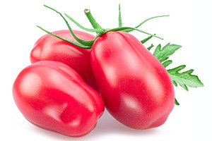 Three pink tomatoes (plums) with tomato leaves isolated on white, a Food & Drink Photo by Volff