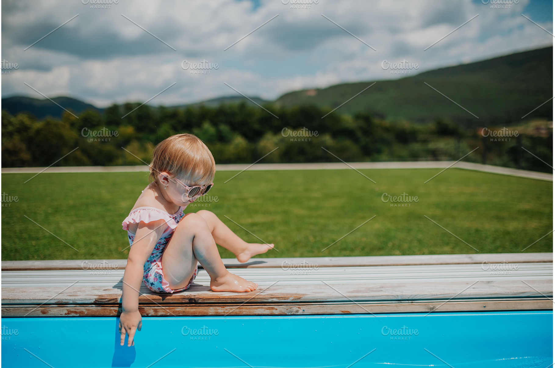 Child sitting by the poolside and, a Person Photo by HalfPoint