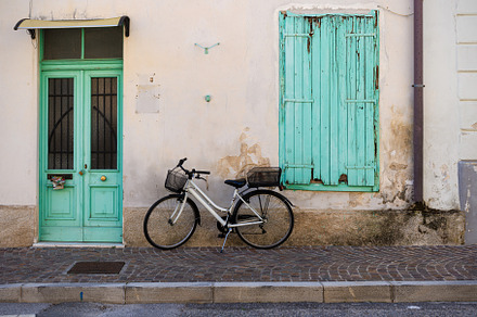 Vintage-style bicycle on the wall of an Italian house, a Transportation Photo by Bepslabor