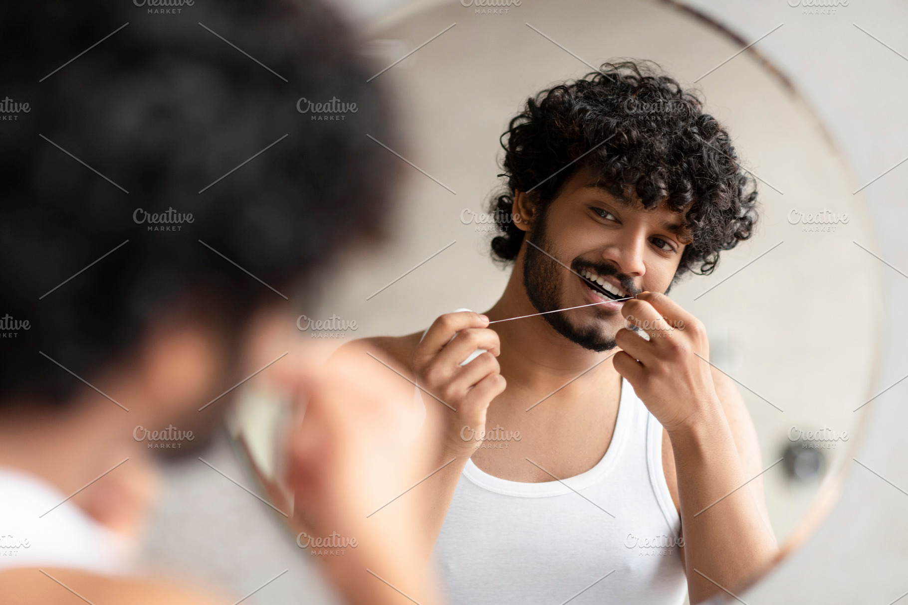 Toothcare concept. Bearded indian man using teeth floss caring for oral hygiene, a Person Photo by Prostock-Studio