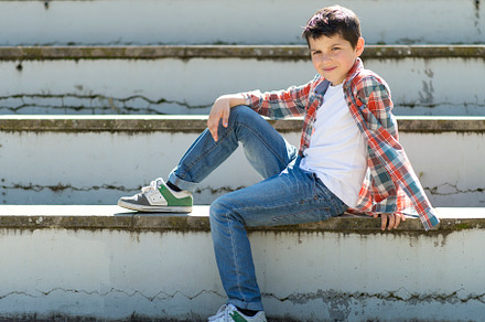 Casual boy sitting on outdoor steps, smiling in sunlight., a Person Photo by RF Images