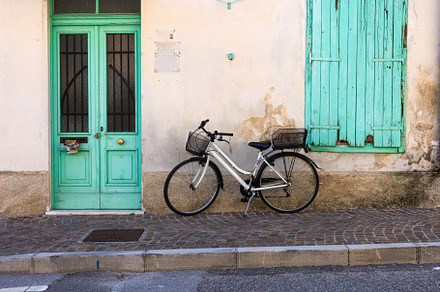 Vintage-style bicycle on the wall of an Italian house, a Transportation Photo by Bepslabor