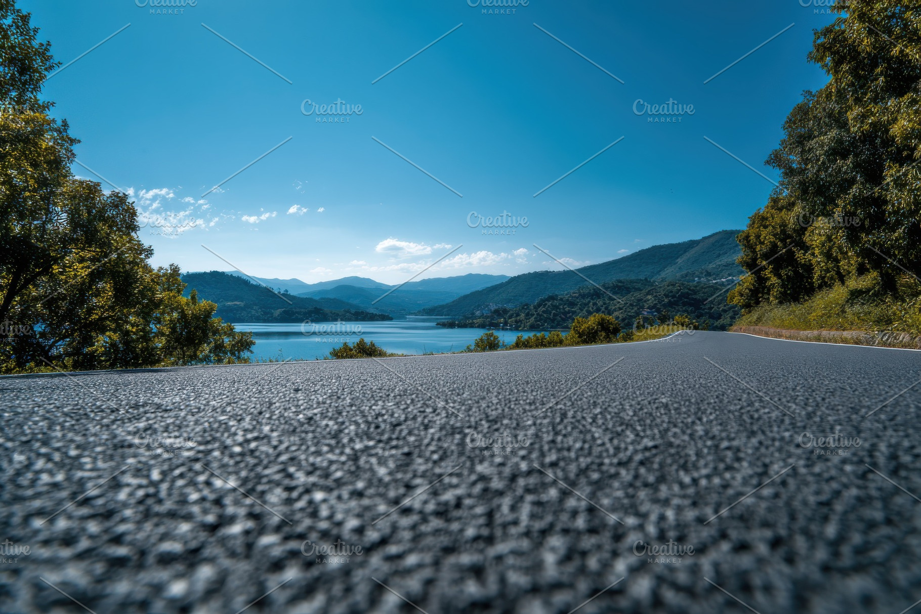 Asphalt road overlooking a tranquil, a Photo by Pixeness Studio