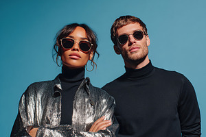 Stylish models showcase modern eyewear against a vibrant blue background, a Photo by AlyaAnd