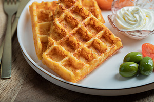 Crunchy waffle fries with sour cream dip served in a basket, a Food & Drink Photo by Budarinphoto