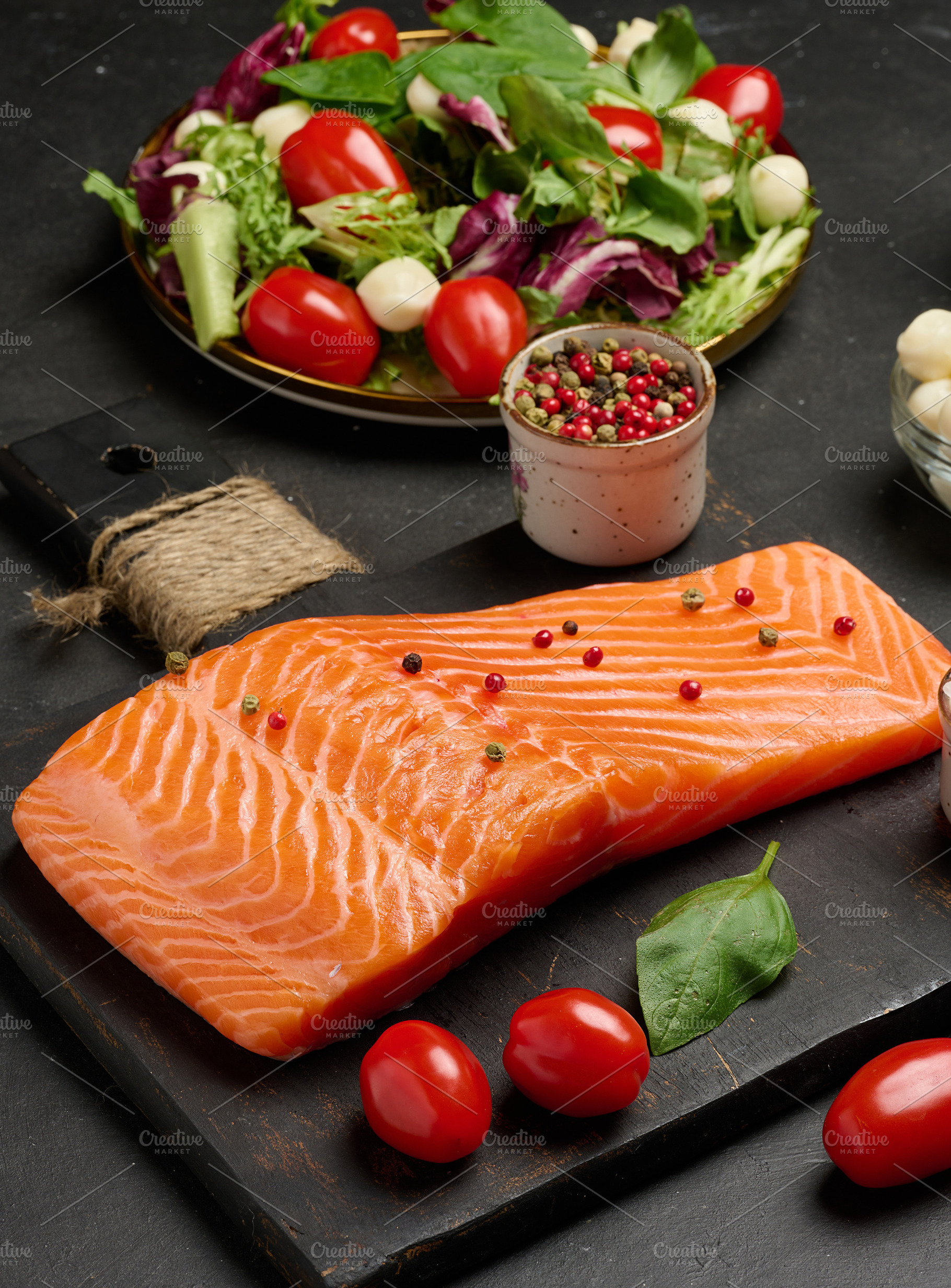 Whole piece of fresh salmon on a black cutting board, next to a, a Food & Drink Photo by ndanko