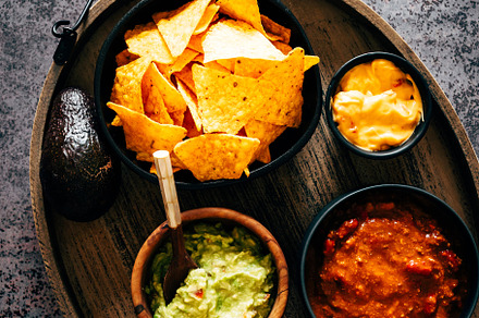 Mexican nachos with guacamole, cheddar cheese and chili.
