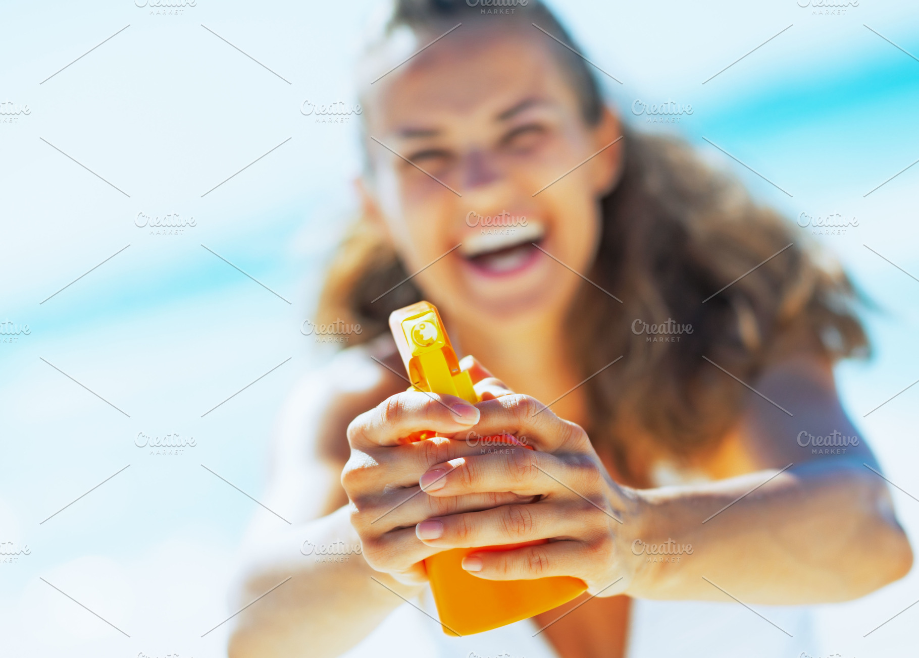 Closeup on young woman pointing bottle of sun block creme in cam, a Person Photo by Alliance Images