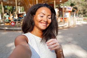 Happy woman with vitiligo skin problem taking selfie in city park, a Person Photo by andreonegin market