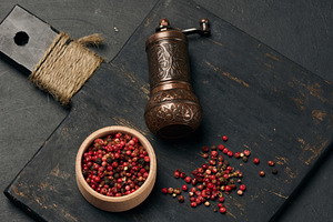 Antique copper pepper shaker and red dried peppercorns on a dark, a Food & Drink Photo by ndanko