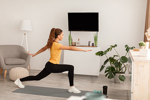 Sporty Black Female Exercising Near Empty TV Screen At Home, a Photo by Prostock-Studio