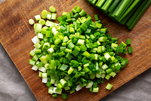 Organic Cut Green Onion Scallions on a Wooden Board, top view., a Food & Drink Photo by LiudmylaChuhunova