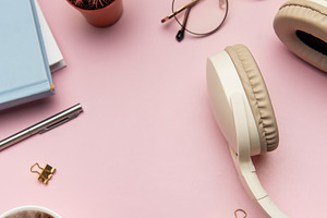 Pink workspace with keyboard, headphones, glasses, coffee, mouse, a Business Photo by Olena Rudo