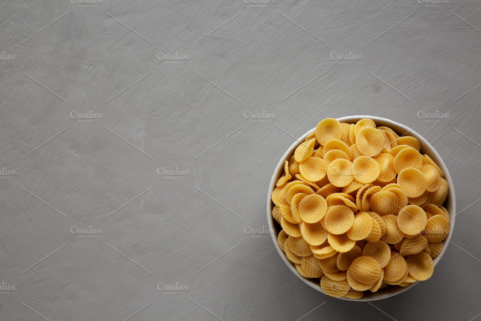 Dry, Uncooked Orecchiette Pasta in a Bowl, top view. Flat lay, o, a Food & Drink Photo by LiudmylaChuhunova