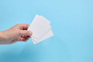 A person holding a fan of blank white business cards against a b, a Business Photo by ndanko