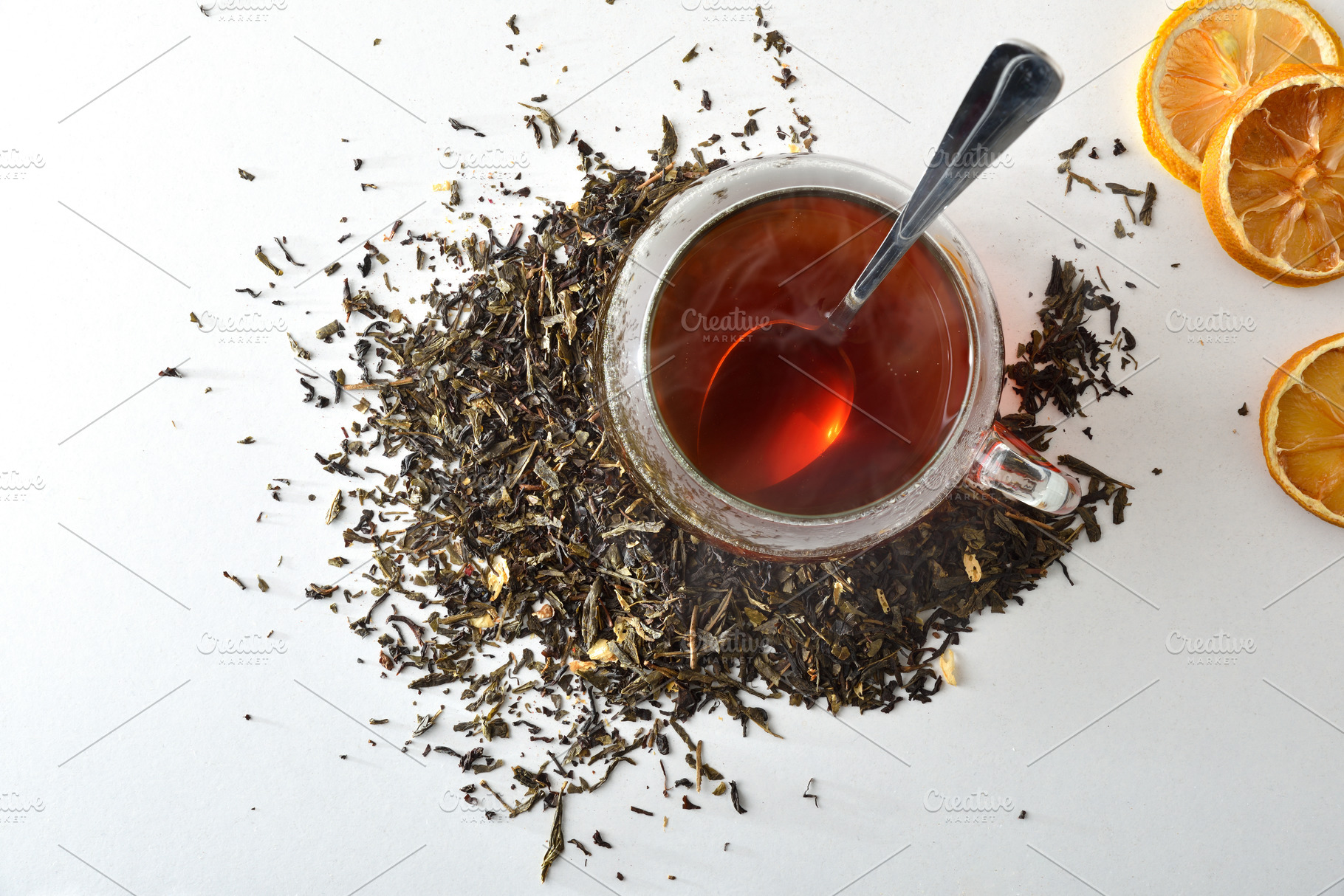 Detail black tea cup leaves scattered on a white table, a Food & Drink Photo by Davizro's Market