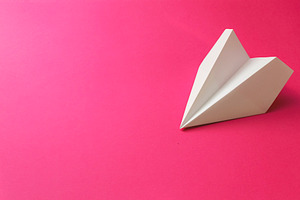 Paper plane on a pink background