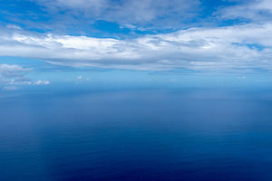 Aerial view of the Pacific Ocean with clouds and deep blue water, a Nature Photo by GoodGoods