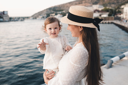 Mother with baby girl over sea, a Person Photo by morrowlight
