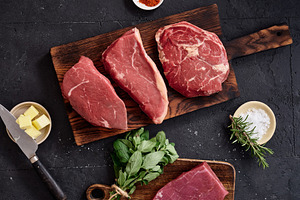Raw rib-eye, roast beef, flank, and rump steak on a wooden cutting board with s, a Food & Drink Photo by Asya Nurullina