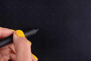 Close-up of a hand holding a stylus on a black graphics tablet w, a Business Photo by Ales Munt