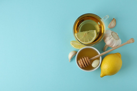 Concept of treatment colds with honey and garlic on blue backgro, a Health & Medical Photo by AtlasStudio PRO