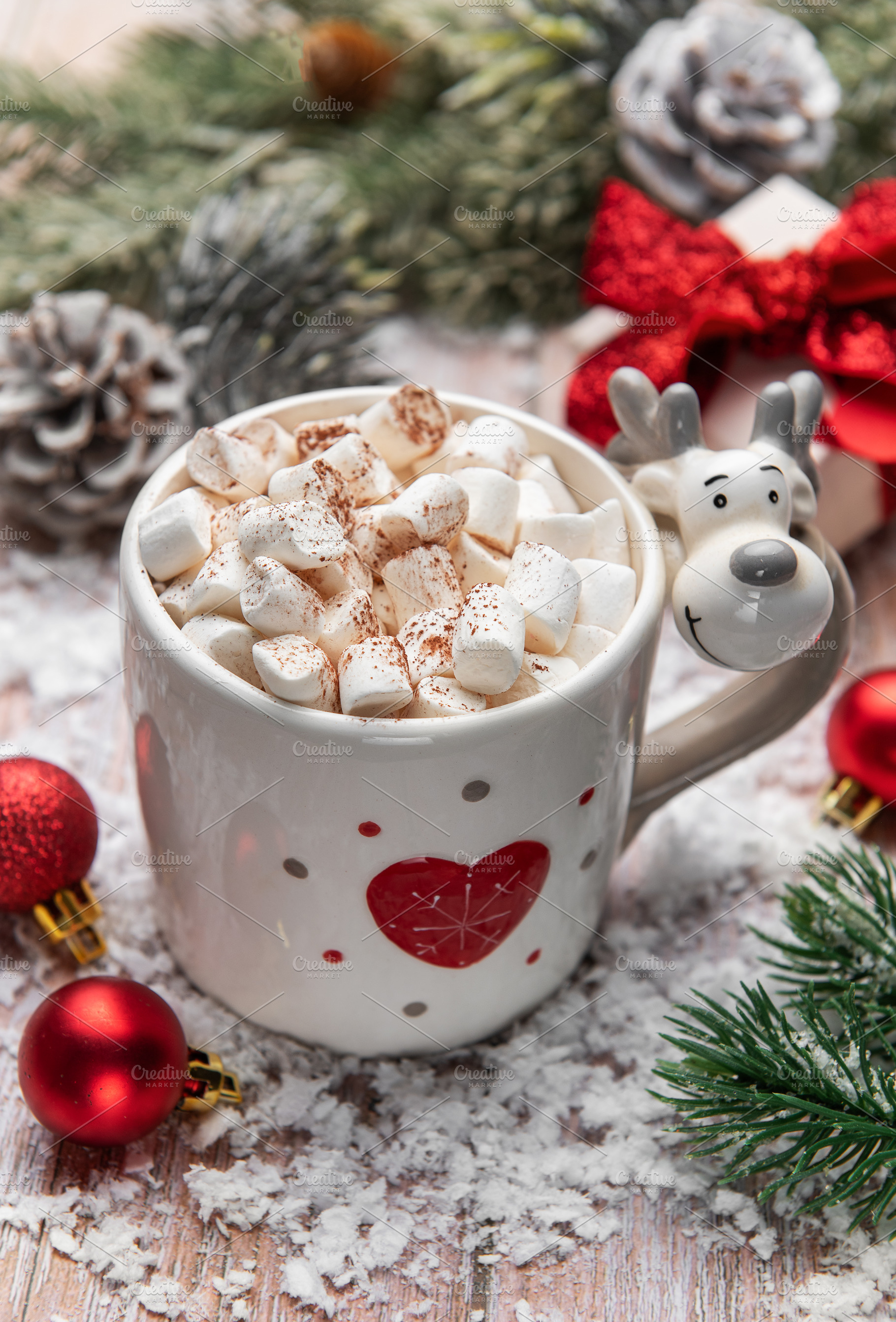 Reindeer mug holding hot chocolate with marshmallows in snow, a Holiday Photo by Olena Rudo